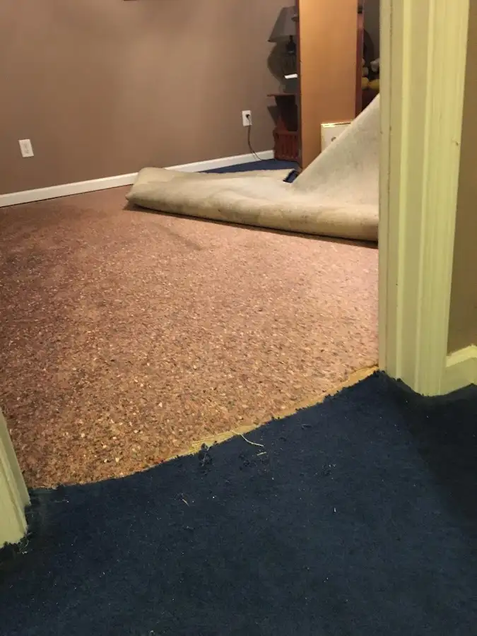 Carpet pad removal revealing water damage during Water Mitigation Services in Conley