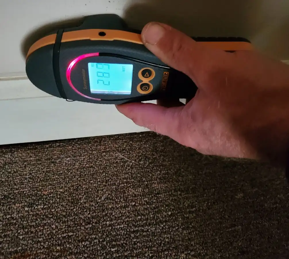 Moisture detection at baseboard during Storm Damage Restoration in Conley